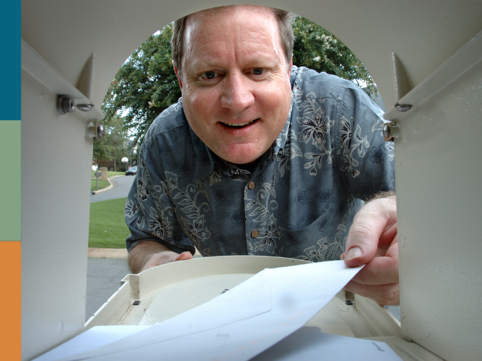 man taking a letter from the IRS out of his mailbox